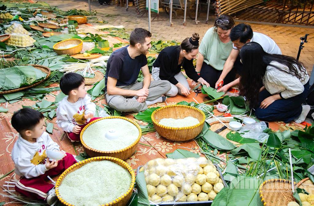 Du khách nước ngoài háo hức học gói bánh chưng. Ảnh: Ngọc Linh