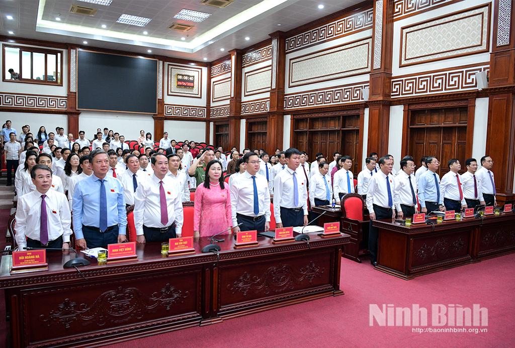 Các đại biểu dự kỳ họp thực hiện nghi thức chào cờ.