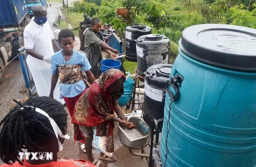Nhân viên y tế hướng dẫn hành khách nhập cảnh rửa tay để phòng lây nhiễm virus Ebola tại điểm kiểm soát biên giới Mpondwe, Uganda. (Ảnh: THX/TTXVN)