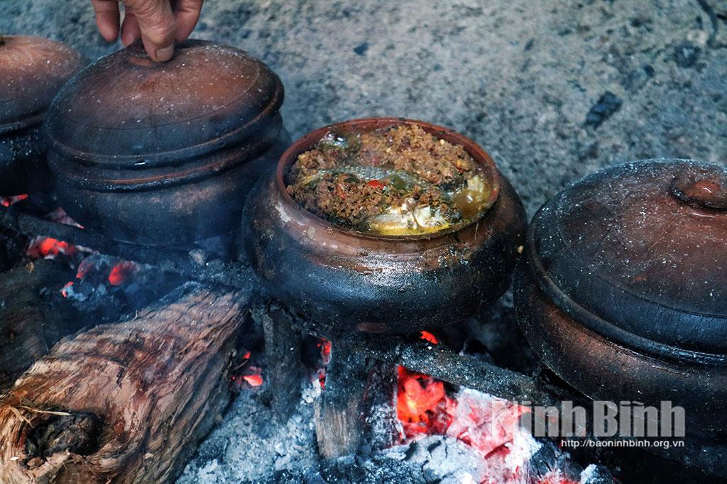 Cá kho chín vàng trên bếp lửa.