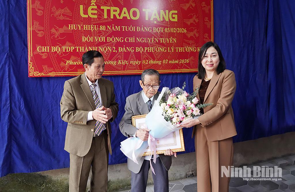 Đồng chí Phó Bí thư Thường trực Tỉnh ủy Đinh Thị Lụa trao tặng Huy hiệu 80 năm tuổi Đảng và tặng hoa chúc mừng đồng chí Nguyễn Tuyên, Chi bộ Tổ dân phố Thanh Nộn 2, Đảng bộ phường Lý Thường Kiệt.