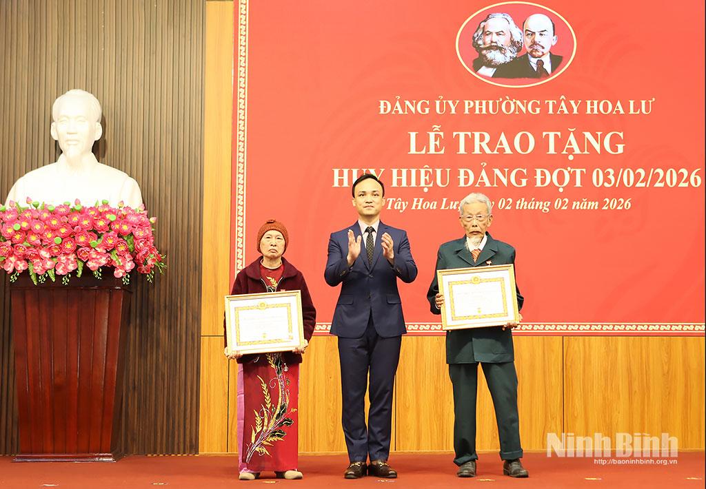 Đồng chí Cao Trường Sơn, Tỉnh ủy viên, Bí thư Đảng ủy phường Tây Hoa Lư trao tặng Huy hiệu 65 năm tuổi Đảng cho các đảng viên. Ảnh: Mạnh Hùng