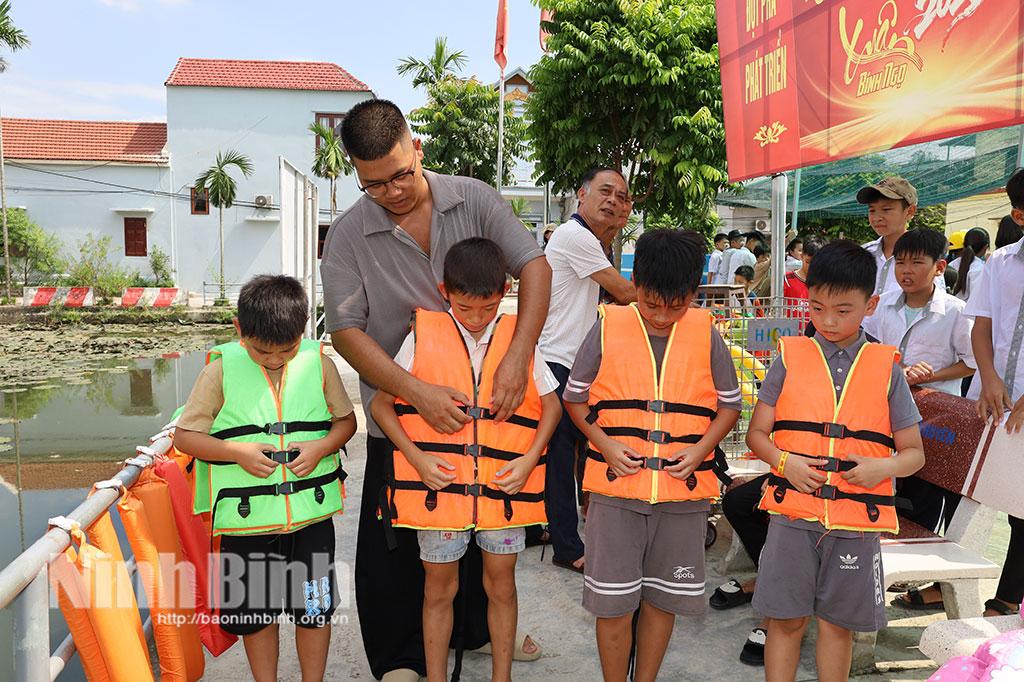 Các em thiếu nhi được hướng dẫn cách sử dụng áo phao.