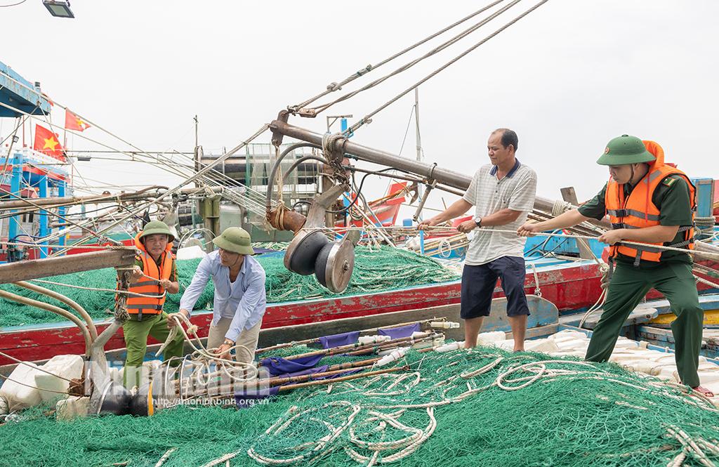 Cán bộ, chiến sĩ Trạm Biên phòng Cửa khẩu cảng Hải Thịnh và Công an xã Hải Thịnh hỗ trợ nhân dân neo tàu, thuyền. Ảnh: Viết Dư