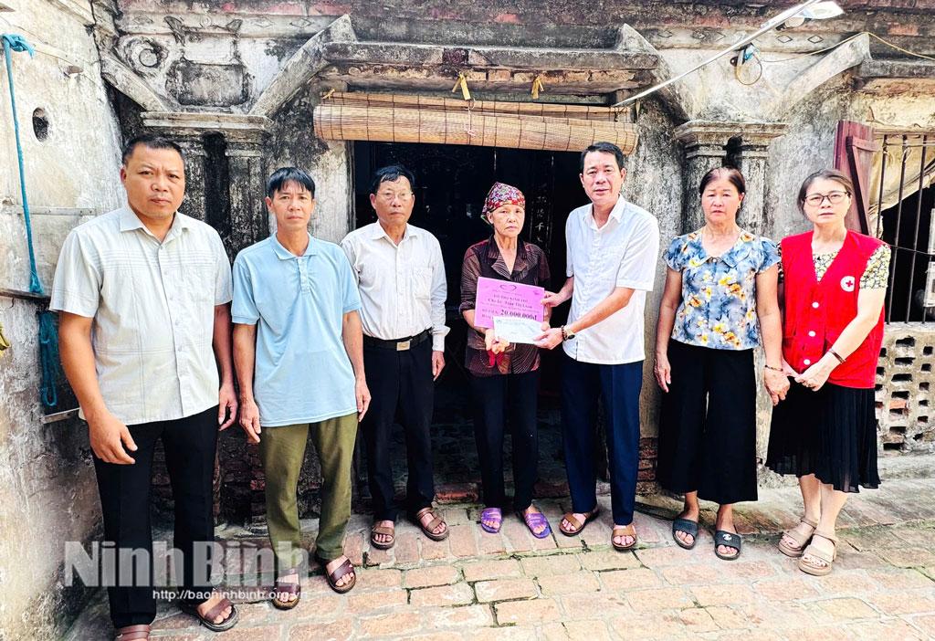 Đồng chí Trần Trọng Tấn, Phó Chủ tịch Hội Chữ thập đỏ tỉnh cùng cấp ủy, chính quyền địa phương trao kinh phí hỗ trợ cho bà Trần Thị Loan.