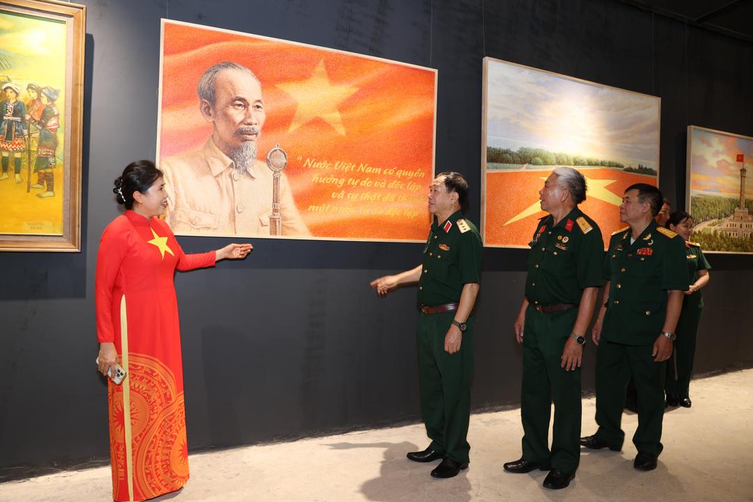 Các đại biểu tham quan, tìm hiểu về từng tác phẩm tại triển lãm (Ảnh: Đình Trung)