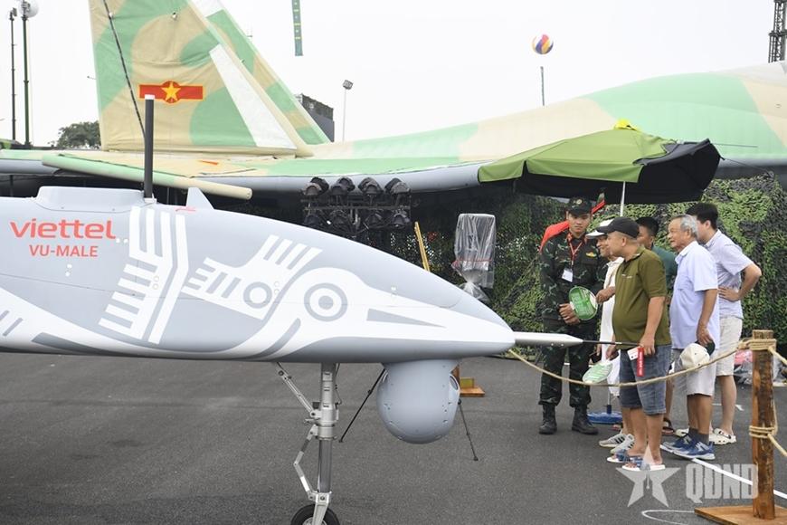 Người dân tham quan, tìm hiểu về máy bay không người lái đa năng tầm xa (VU-MALE) do Tập đoàn Công nghiệp - Viễn thông Quân đội (Viettel) tự nghiên cứu chế tạo, đặt tại khu trưng bày ngoài trời của Bộ Quốc phòng. Ảnh: TUẤN HUY