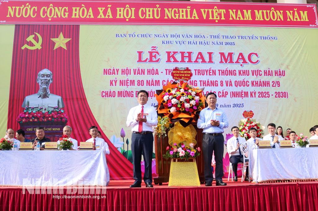 Đồng chí Bùi Ngọc Quang, Tỉnh uỷ viên, Phó Tổng Biên tập Báo và Phát thanh, Truyền hình Ninh Bình tặng hoa chúc mừng Ban tổ chức Ngày hội.