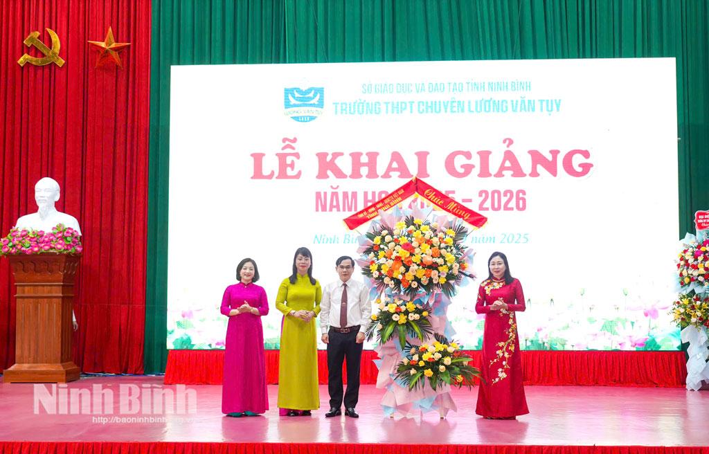 Đồng chí Phó Bí thư Thường trực Tỉnh ủy Đinh Thị Lụa tặng hoa chúc mừng thầy và trò Trường THPT chuyên Lương Văn Tụy.