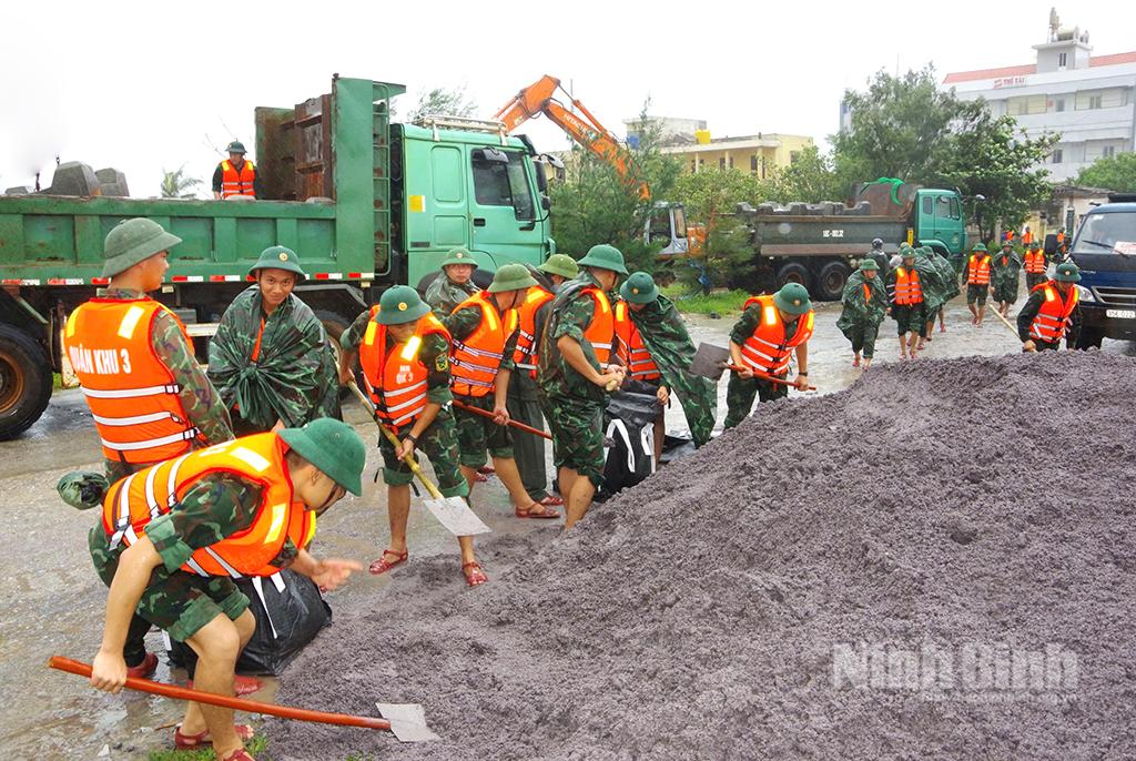 Cán bộ, chiến sỹ LLVT tỉnh Ninh Bình đắp bao cát xử lý sự cố tại đê kè xã Hải Thịnh.