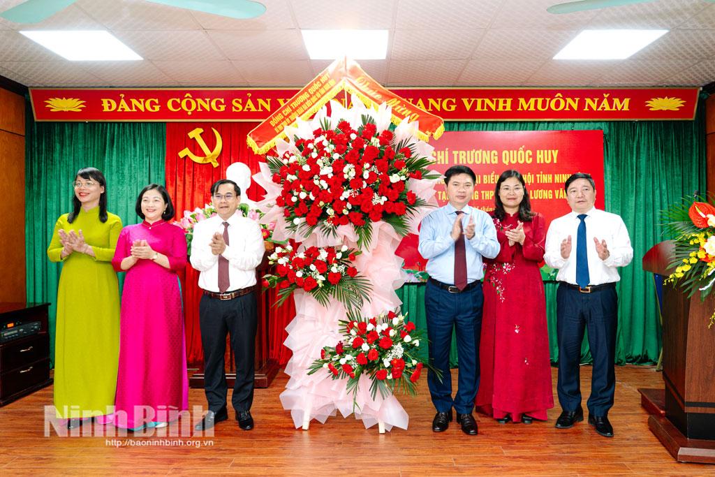 Đồng chí Bí thư Tỉnh ủy Trương Quốc Huy và đoàn công tác tặng hoa chúc mừng thầy và trò Trường THPT chuyên Lương Văn Tụy.