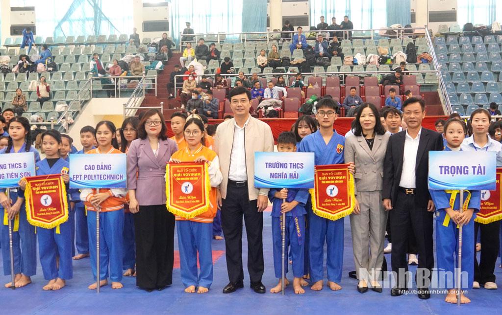 Các đại biểu trao Cờ lưu niệm cho các đoàn VĐV tham gia thi đấu tại Giải Vovinam tỉnh Ninh Bình năm 2025.
