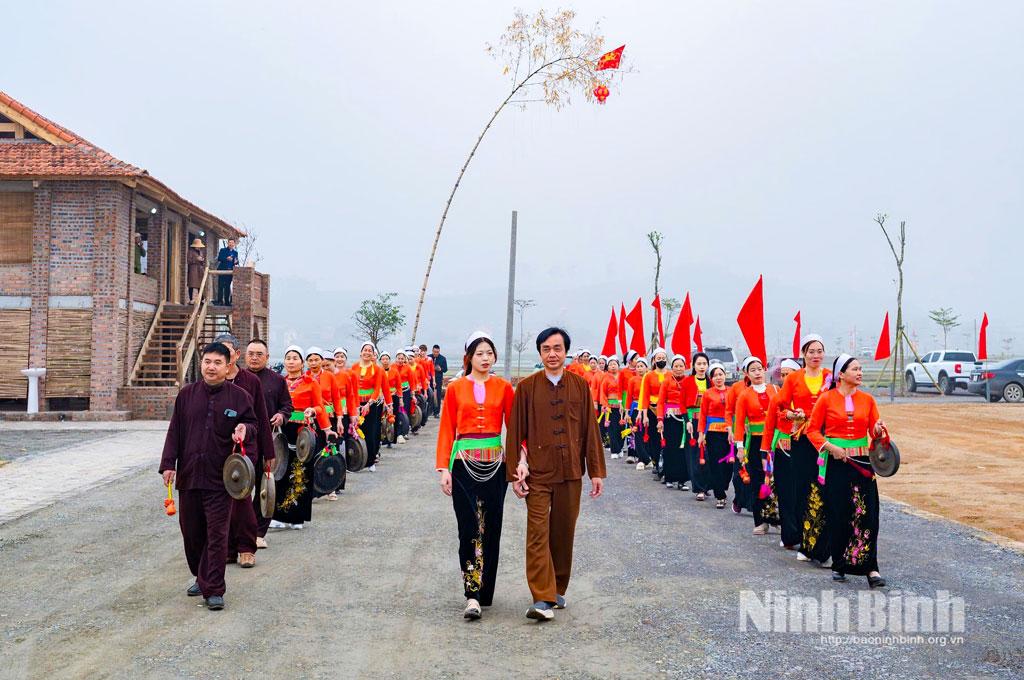 Đoàn rước dâu rộn ràng đi trên đường làng với đội cồng chiêng đi hai bên.