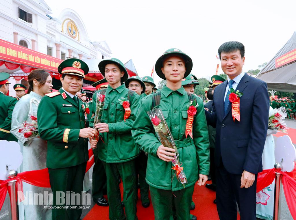 Đại tướng Nguyễn Tân Cương và Bí thư Tỉnh ủy Trần Huy Tuấn tặng hoa, động viên các tân binh tại lễ giao nhận quân. Ảnh: Việt Thắng