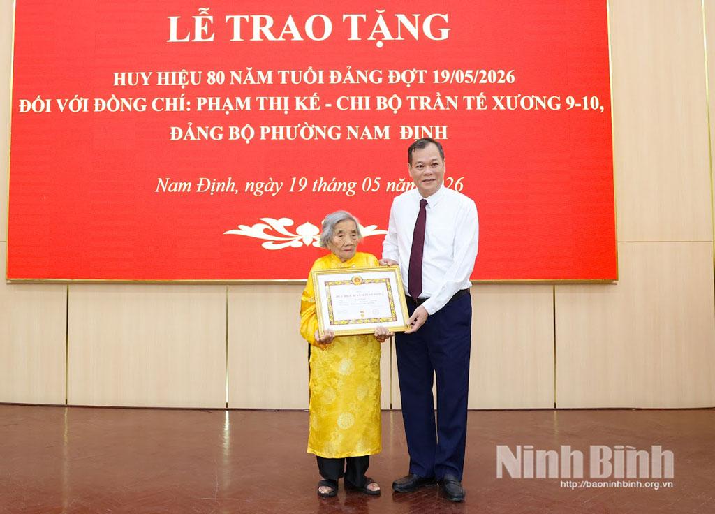 Đồng chí Lê Quốc Chỉnh, Phó Bí thư Tỉnh ủy, Chủ tịch HĐND tỉnh trao Huy hiệu 80 năm tuổi Đảng cho đồng chí Phạm Thị Kế.