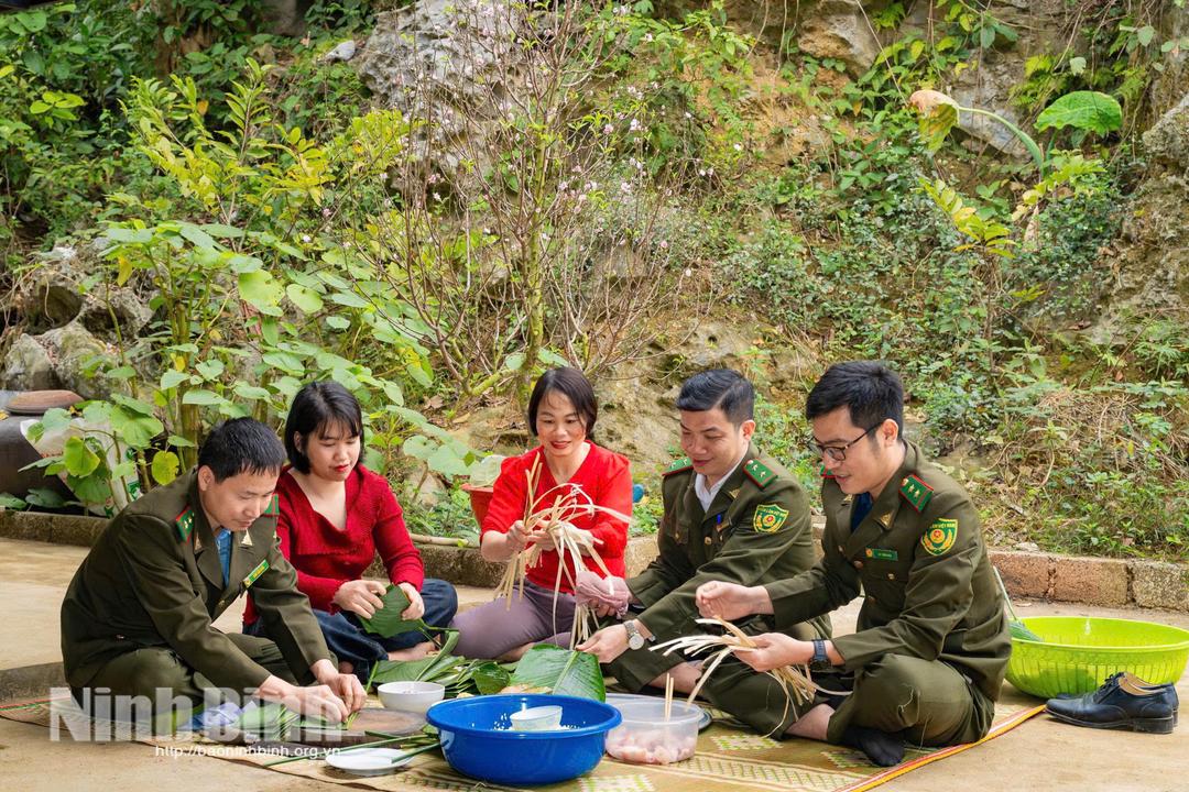 Cán bộ Hạt Kiểm lâm Khu vực 2 gói bánh chưng đón Tết cùng người dân xã Gia Lâm. Ảnh: Ngọc Linh