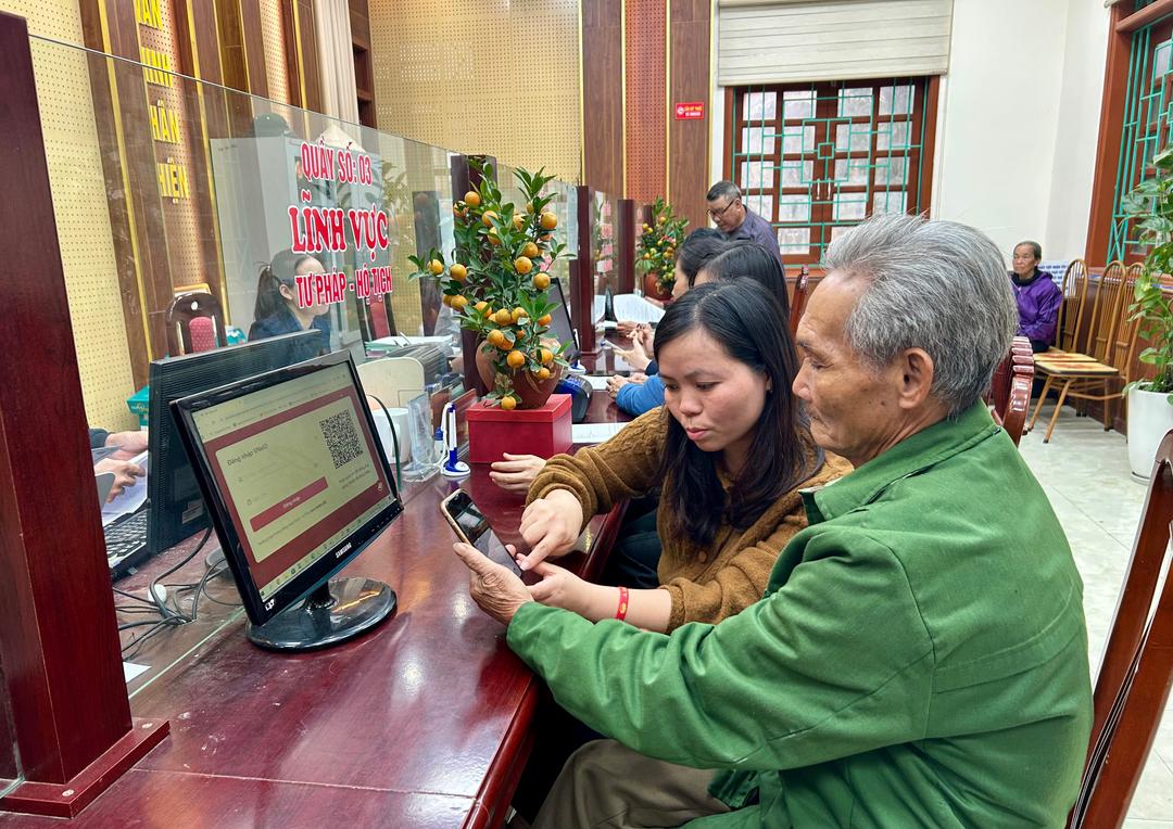 Thành viên Tổ công nghệ số cộng đồng xã Đồng Thái hướng dẫn người dân thực hiện thủ tục hành chính trên Cổng dịch vụ công trực tuyến.