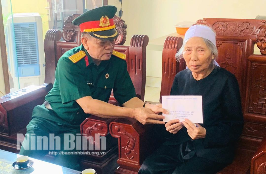 Đại diện các nhà hảo tâm trao số tiền 10 triệu đồng tặng bà Phan Thị Xây là vợ của liệt sĩ Đinh Xuân Ất.