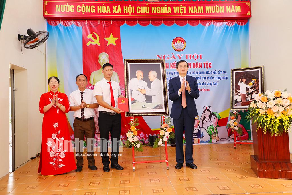 Đồng chí Bí thư Tỉnh uỷ Đoàn Minh Huấn tặng bức ảnh "Bác Hồ và Bác Tôn bắt tay kết đoàn" cho nhân dân và cán bộ tổ dân phố Tân Nhất (Nho Quan). Ảnh: Đức Lam