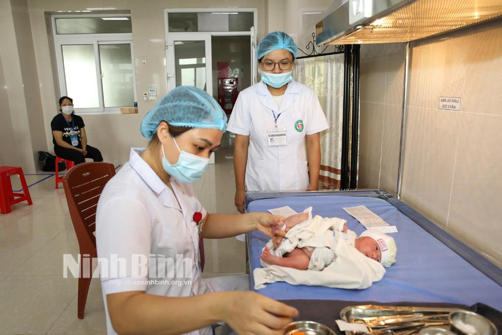 Thực hiện lấy máu gót chân để sàng lọc sơ sinh gói 8 bệnh ở trẻ sơ sinh. Ảnh: Minh Quang