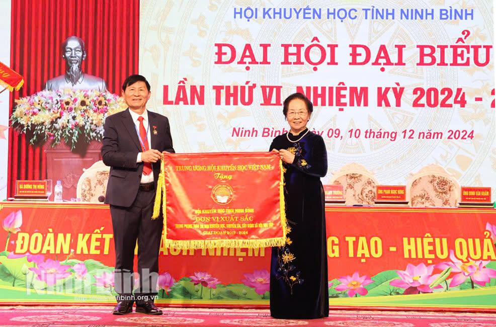 GS.TS Nguyễn Thị Doan, nguyên Ủy viên Trung ương Đảng, nguyên Phó Chủ tịch nước, Chủ tịch Hội Khuyến học Việt Nam trao Cờ thi đua xuất sắc của Hội Khuyến học Việt Nam cho Hội Khuyến học tỉnh.