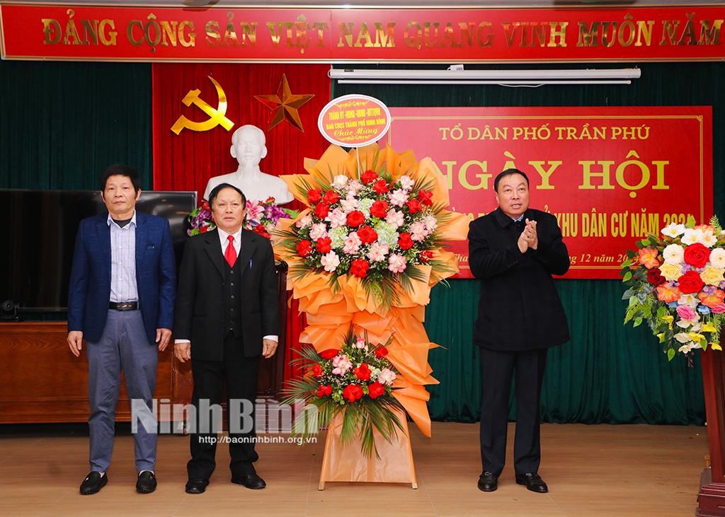 Đồng chí Bí thư Thành uỷ Đinh Văn Tiên tặng hoa chúc mừng cán bộ, nhân dân phố Trần Phú tại Ngày hội.