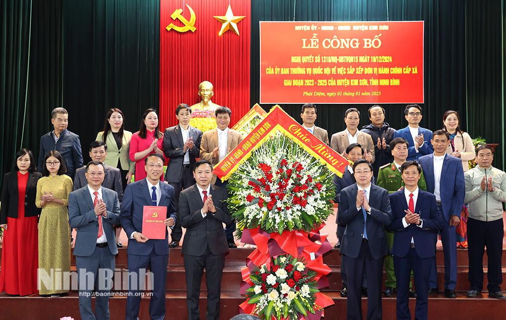 Đồng chí Bí thư Huyện ủy Kim Sơn Mai Khanh trao quyết định, tặng hoa chúc mừng các đồng chí trong Ban Thường vụ Đảng ủy thị trấn Phát Diệm (sau sáp nhập). Ảnh: Minh Quang