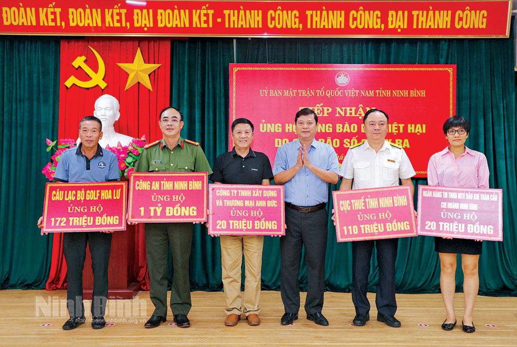 Đại diện Ủy ban MTTQ Việt Nam tỉnh tiếp nhận biển biểu trưng của các cơ quan, doanh nghiệp ủng hộ đồng bào bị thiệt hại do bão số 3. Ảnh: Đức Lam