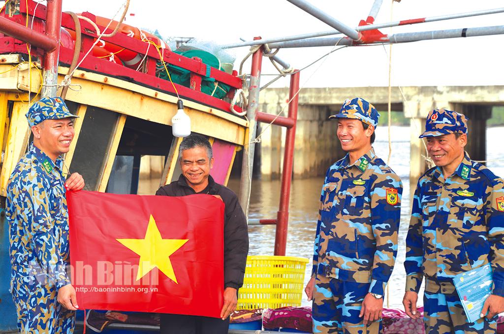 Bộ đội Biên phòng trao cờ Tổ quốc cho tàu đánh cá của ngư dân.