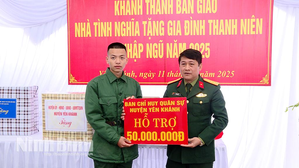 Lãnh đạo Ban CHQS huyện trao biển biểu trưng số tiền hỗ trợ xây dựng nhà cho thanh niên Nguyễn Văn Tuấn, xóm Bắc, xã Khánh Lợi.