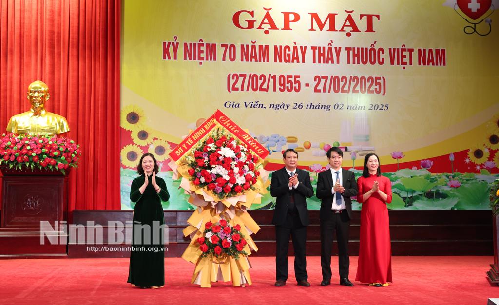 Lãnh đạo Sở Y tế tặng hoa chúc mừng cán bộ, y, bác sỹ Trung tâm Y tế huyện Gia Viễn. Ảnh: Minh Quang