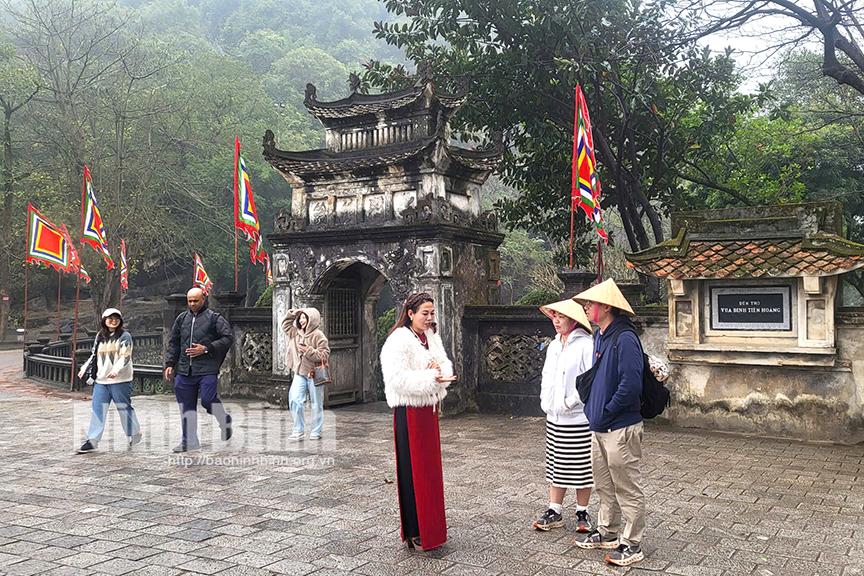 Hướng dẫn viên Trung tâm Bảo tồn di tích lịch sử văn hoá Cố đô Hoa Lư thuyết minh cho du khách về giá trị di tích lịch sử.