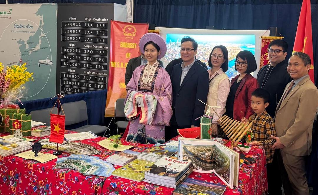Đại sứ Phạm Vinh Quang (thứ hai bên trái) chụp ảnh cùng cán bộ nhân viên Đại sứ quán và đại diện của các hãng du lịch và hàng không tại gian hàng Việt Nam ở Triển lãm du lịch và kỳ nghỉ. Ảnh: TTXVN