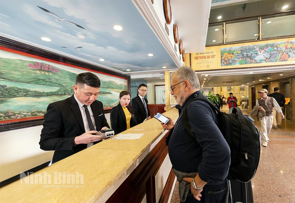 Nhân viên Khách sạn Hoàng Sơn Peace hướng dẫn du khách làm thủ tục.