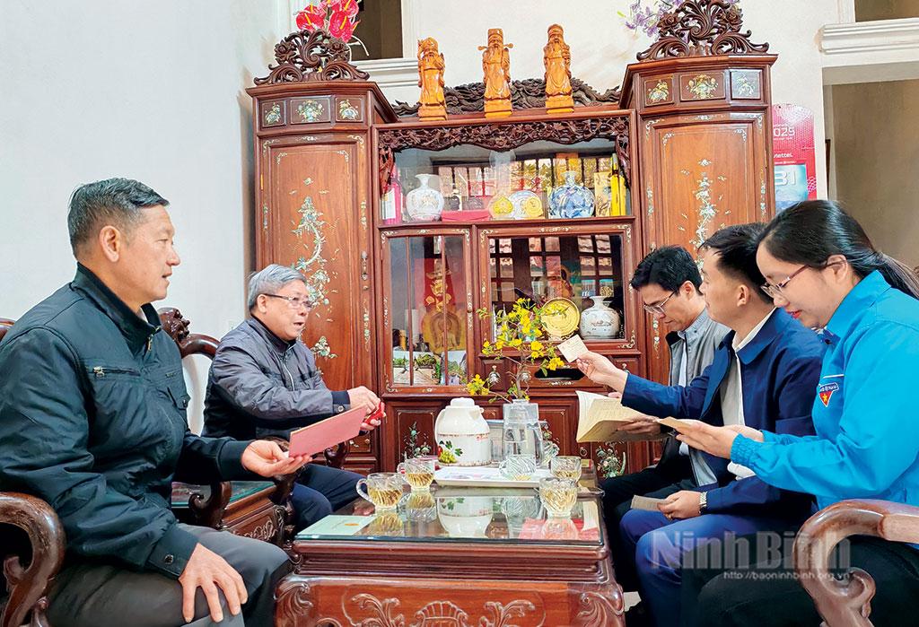 Ông Lê Văn Đáng (người thứ 2, từ trái sang) chia sẻ những kỷ niệm về thời thanh xuân rực lửa với cán bộ phường Tân Thành (thành phố Hoa Lư).