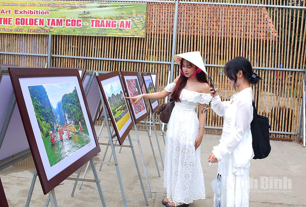 Khách du lịch xem ảnh tại triển lãm ảnh nghệ thuật “Mùa vàng Tam Cốc-Tràng An”.