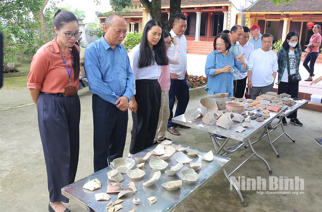 Các đại biểu tìm hiểu, trao đổi thông tin về những hiện vật khảo cổ đã được tìm thấy.
