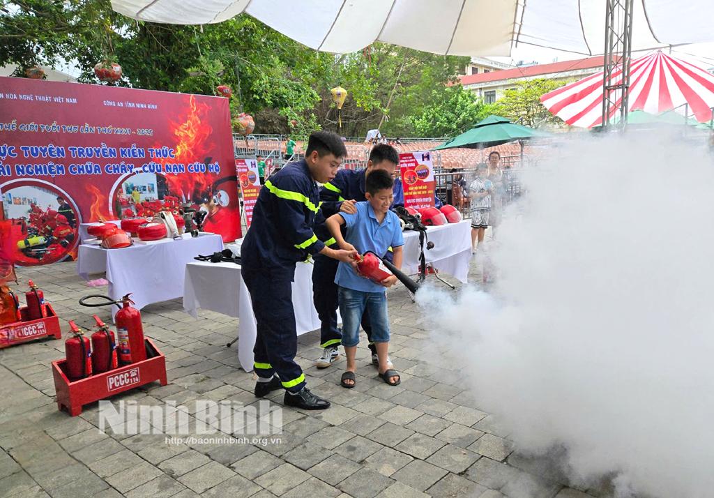 Cán bộ phòng Cảnh sát PCCC&CNCH, Công an tỉnh hướng dẫn các em thiếu nhi sử dụng bình chữa cháy.