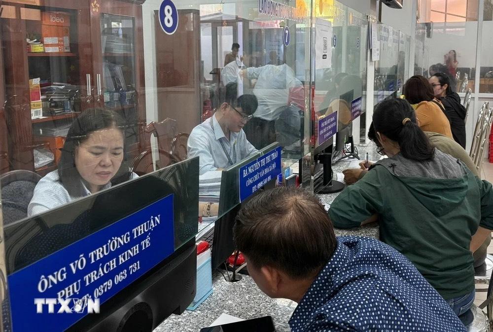 Người dân làm thủ tục hành chính. (Ảnh: TTXVN)