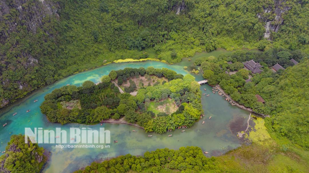 Toàn cảnh đền Suối Tiên (Khu du lịch sinh thái Tràng An), nhìn từ trên cao nước xanh như ngọc, thuyền xuôi nhẹ giữa rừng núi.