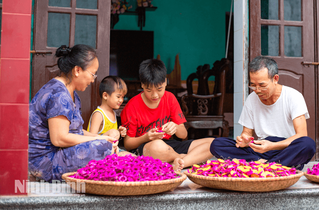 Vợ chồng ông Nguyễn Đức Hưởng, làng Báo Đáp, phường Hồng Quang hướng dẫn các cháu nhỏ làm trống bỏi.