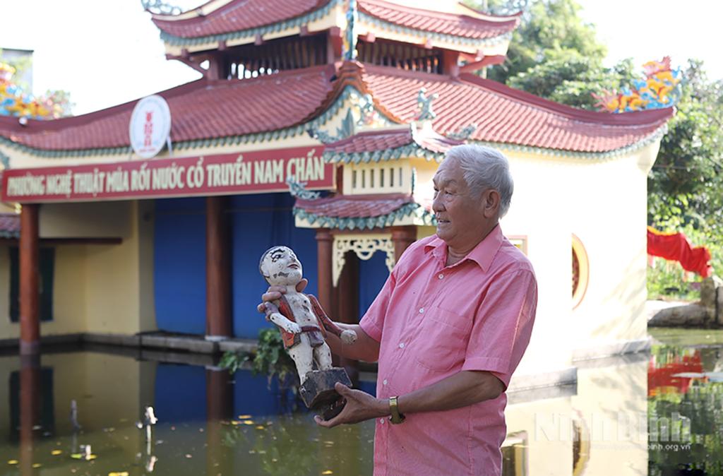 Nghệ nhân cao tuổi của phường múa rối nước giới thiệu chú Tễu nhân vật biểu tượng trong múa rối nước.