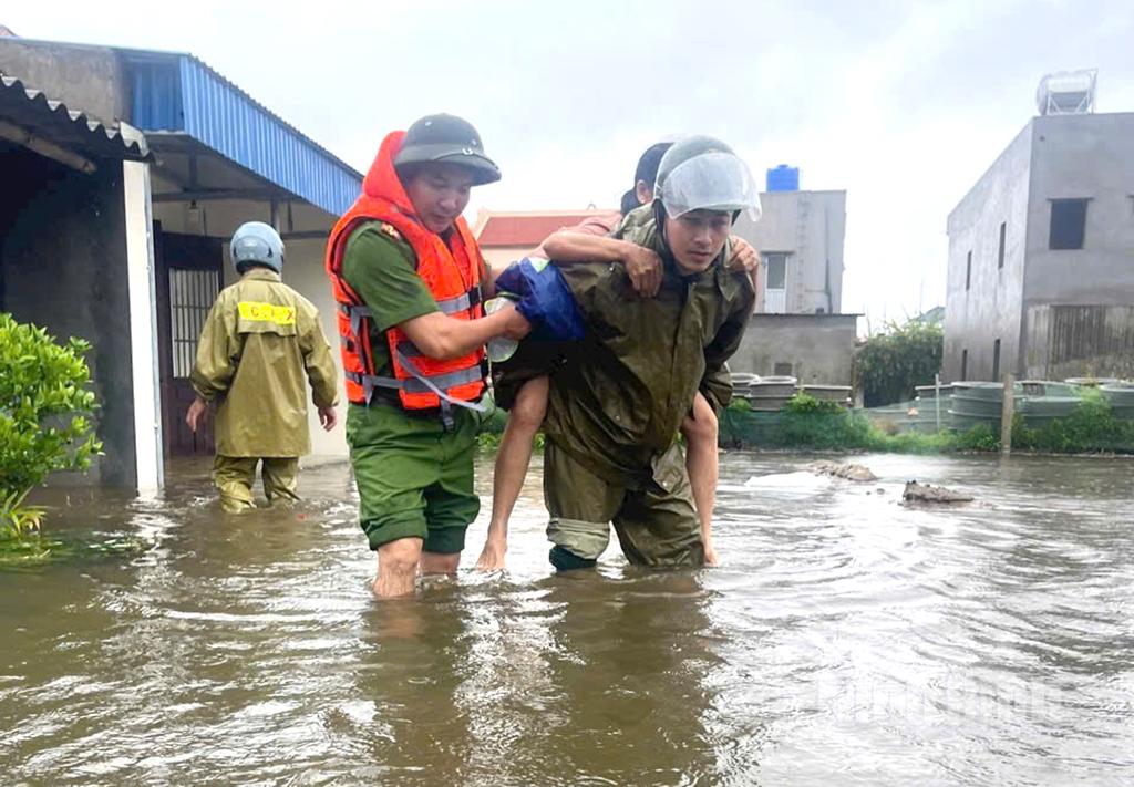 Công an xã Hải Thịnh giúp người dân vùng nguy cơ ngập lụt di chuyển vào nơi an toàn.
