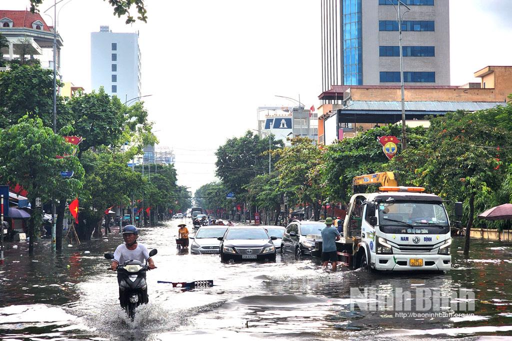 Đoạn đường Trần Hưng Đạo từ khu vực cổng trường Đại học Kinh tế kỹ thuật Công nghiệp Nam Định đến qua ngã tư Quang Trung vẫn đang trong tình trạng ngập sâu, nhiều phương tiện ô tô phải gọi xe cứu hộ.