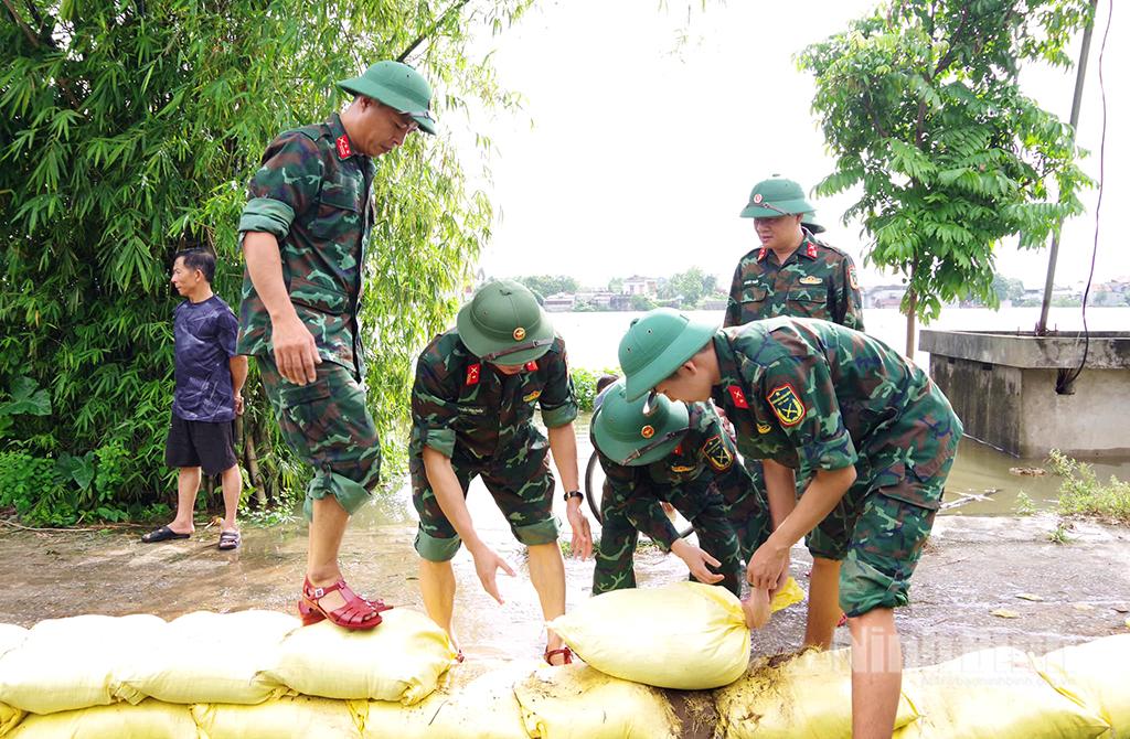 Cán bộ chiến sỹ Ban Chỉ huy phòng thủ khu vực 1-Phù Vân khẩn trương giúp nhân dân ứng phó với nguy cơ ngập lụt tại phường Phù Vân do nước sông Đáy dâng cao. Ảnh: Hoa Hiên
