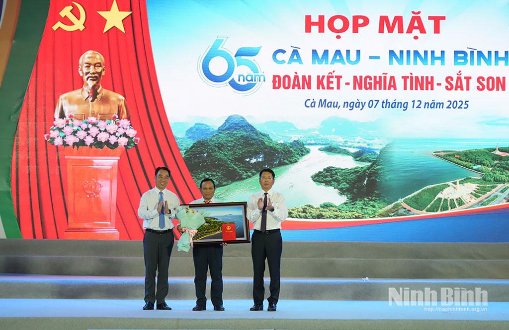 Đồng chí Chủ tịch UBND tỉnh Cà Mau Lữ Quang Ngời và đồng chí Phó Chủ tịch Thường trực UBND tỉnh Ninh Bình Trần Song Tùng trao tặng vật phẩm lưu niệm cho đại diện Ban Liên lạc đồng hương Ninh Bình tại tỉnh Cà Mau.