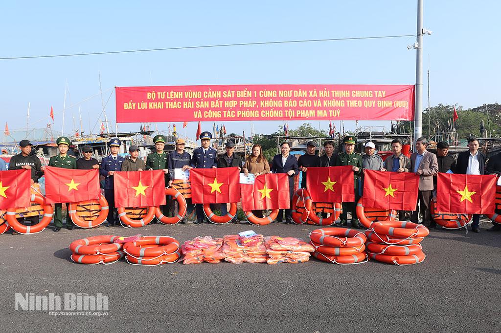 Lãnh đạo Bộ tư lệnh Vùng Cảnh sát biển 1 và Ban Tuyên giáo và Dân vận Tỉnh ủy trao áo phao, phao cho ngư dân tại Cảng cá Ninh Cơ.