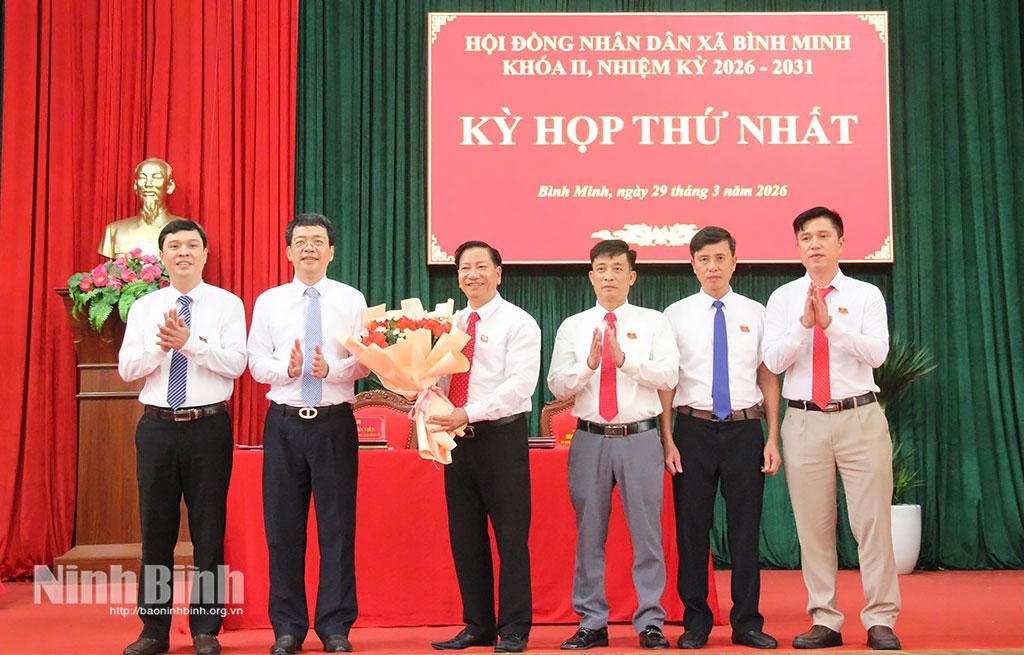 Đồng chí Khúc Mạnh Kiên, Tỉnh uỷ viên, Phó Trưởng Ban Tuyên giáo và Dân vận Tỉnh uỷ tặng hoa chúc mừng các đồng chí được bầu giữ các chức danh lãnh đạo HĐND xã Bình Minh. Ảnh: Minh Hải