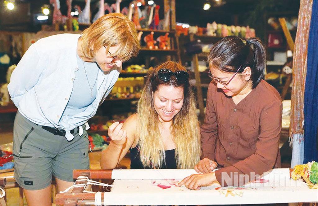 Du khách nước ngoài trải nghiệm nghề thêu Văn Lâm, phường Nam Hoa Lư.